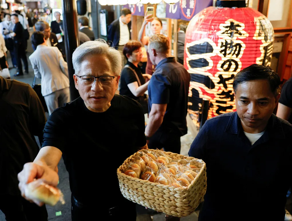 CEO Nvidia Jensen Huang phát bánh bao ở Tokyo. Ảnh: Reuters