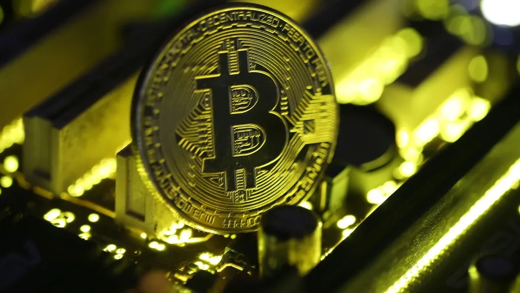 Một đồng xu biểu trưng của Bitcoin được đặt trên các bo mạch điện tử. Ảnh: CNBC